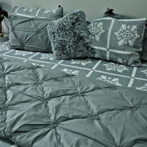 Slate grey pinch pleat comforter set with white geometric snowflake pattern sheets and grey faux fur cushion