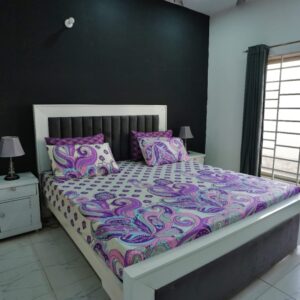 Vibrant purple and teal paisley swirl print pure cotton bed sheet set on a modern white bed